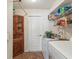 This laundry room includes a washer, dryer, cabinet space and built in shelving at 6028 Dorset Rd, Spring Hill, FL 34608
