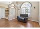 Cozy living room with wood floors, arched window, and comfortable gray recliner at 6028 Dorset Rd, Spring Hill, FL 34608