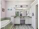 An airy main bathroom featuring and sinks, a large mirror and tile floors at 6028 Dorset Rd, Spring Hill, FL 34608