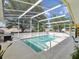 Inviting screened-in pool area with patio, lush landscaping and outdoor grill at 6028 Dorset Rd, Spring Hill, FL 34608