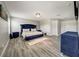 A spacious bedroom with gray walls, hard flooring, a blue bed set, and a crystal light fixture at 6222 Cherry Blossom Trl, Gibsonton, FL 33534
