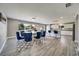 Open-concept dining area with stylish blue chairs, hardwood floors, and ample natural light at 6222 Cherry Blossom Trl, Gibsonton, FL 33534