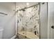 Modern bathroom with white marble-style tiled shower with glass door and rainfall shower head at 6222 Cherry Blossom Trl, Gibsonton, FL 33534