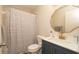 Bright bathroom featuring a modern sink with gold faucet and a bathtub with patterned shower curtain at 6309 Covewood Dr, Spring Hill, FL 34609