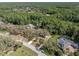 An aerial view shows a home nestled among lush trees and greenery on a spacious lot at 6454 Summerfield Loop, Trinity, FL 34655