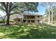 A lush backyard features a home with a covered patio and balcony, ideal for relaxation and outdoor living at 6454 Summerfield Loop, Trinity, FL 34655