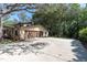 A sprawling driveway leads to a three-car garage, complemented by mature trees and lush landscaping at 6454 Summerfield Loop, Trinity, FL 34655