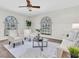 Bright living room featuring large windows, plush seating, a ceiling fan, and a neutral color palette at 6454 Summerfield Loop, Trinity, FL 34655