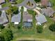 Aerial view of a home with a screened-in pool, surrounded by greenery and mature trees at 7175 Bottle Brush Dr, Spring Hill, FL 34606