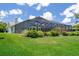 Sprawling backyard featuring a screened-in pool and lush green lawn at 7175 Bottle Brush Dr, Spring Hill, FL 34606