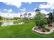Expansive backyard with lake view, lush lawn, and manicured landscaping at 7175 Bottle Brush Dr, Spring Hill, FL 34606