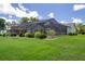 Green backyard with manicured landscaping and screened-in pool at 7175 Bottle Brush Dr, Spring Hill, FL 34606
