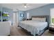 Comfortable bedroom featuring blue walls, a cozy bed with patterned bedding, and ample natural light at 7175 Bottle Brush Dr, Spring Hill, FL 34606