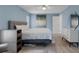 Comfortable bedroom featuring blue walls, a cozy bed with patterned bedding, and neutral colored furniture at 7175 Bottle Brush Dr, Spring Hill, FL 34606