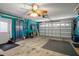 Spacious garage with tools, a garage door, and a ceiling fan at 7175 Bottle Brush Dr, Spring Hill, FL 34606