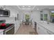 Bright, white kitchen with modern appliances and granite countertops, open to the dining area and backyard views at 7175 Bottle Brush Dr, Spring Hill, FL 34606