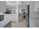 Modern kitchen with white cabinetry, stainless steel appliances, and open view into living space at 7175 Bottle Brush Dr, Spring Hill, FL 34606