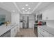 Bright kitchen boasts recessed lighting, stainless steel appliances, white cabinets, and stone countertops at 7175 Bottle Brush Dr, Spring Hill, FL 34606