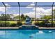 Tranquil screened-in pool with dolphin statue water feature and manicured landscaping at 7175 Bottle Brush Dr, Spring Hill, FL 34606