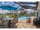 Screened-in pool area with outdoor dining and seating, clear blue water, and brick pavers at 7175 Bottle Brush Dr, Spring Hill, FL 34606