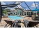 Inviting pool area with outdoor seating, clear blue water, and manicured landscaping at 7175 Bottle Brush Dr, Spring Hill, FL 34606