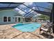 A beautiful screened-in pool with brick pavers, clear blue water, and a dolphin statue feature at 7175 Bottle Brush Dr, Spring Hill, FL 34606