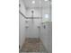 Modern walk-in shower featuring a pebble floor and decorative tiled accent wall at 7175 Bottle Brush Dr, Spring Hill, FL 34606