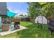 Spacious backyard featuring a patio, grill, gazebo, and mature trees at 7422 New York Ave, Hudson, FL 34667