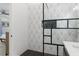 Shower with black and white geometric tile and glass enclosure at 7422 New York Ave, Hudson, FL 34667