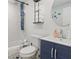 Bathroom with navy vanity, unique shower fixture, and coastal themed decor at 7422 New York Ave, Hudson, FL 34667
