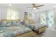 Bright bedroom with two beds featuring coastal-themed bedding and decor, lit by ceiling fan at 7422 New York Ave, Hudson, FL 34667