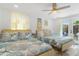 Bright bedroom with two beds featuring coastal-themed bedding and decor, with access to patio at 7422 New York Ave, Hudson, FL 34667