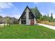 Charming A-frame house with a unique design, highlighted by striking black trim and expansive lawn at 7422 New York Ave, Hudson, FL 34667
