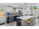 Bright kitchen with white cabinets, stainless steel appliances, breakfast bar, and a modern backsplash at 7422 New York Ave, Hudson, FL 34667