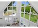 Bright and airy living room featuring a soaring ceiling, large windows, and white shiplap walls at 7422 New York Ave, Hudson, FL 34667