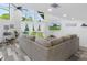 Bright living room featuring a vaulted ceiling, large windows, and comfortable seating area at 7422 New York Ave, Hudson, FL 34667