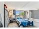 Bright bedroom featuring a floral patterned bedspread, natural light, and a functional desk area at 7535 Christina Ln, Port Richey, FL 34668