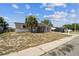 Home exterior with a palm tree, driveway, and front yard, showcasing the property's curb appeal at 7535 Christina Ln, Port Richey, FL 34668