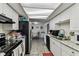 Spacious galley kitchen featuring white cabinets, granite countertops, and a view of the dining area at 7535 Christina Ln, Port Richey, FL 34668