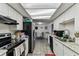 Spacious galley kitchen featuring white cabinets, granite countertops, and a view of the dining area at 7535 Christina Ln, Port Richey, FL 34668