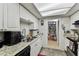 Galley kitchen with granite countertops, white cabinets, and walk-in pantry at 7535 Christina Ln, Port Richey, FL 34668