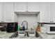 Galley kitchen with granite countertops and white cabinets at 7535 Christina Ln, Port Richey, FL 34668