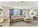 Bright living room showcasing a sectional sofa, plush carpet, and plenty of natural light at 7535 Christina Ln, Port Richey, FL 34668