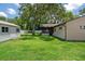 This spacious backyard features a well-manicured lawn and mature trees plus a storage shed at 7630 Landmark Dr, Spring Hill, FL 34606