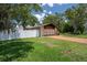 A well-manicured lawn and a driveway that leads to a spacious two-car garage and a white fence on the left at 7630 Landmark Dr, Spring Hill, FL 34606