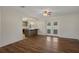 Open-concept living room with hardwood floors, ceiling fan, and views to the kitchen at 7630 Landmark Dr, Spring Hill, FL 34606