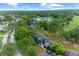 An aerial view shows the condo buildings nestled amongst mature trees, a pond, and a golf course at 7682 St Andrews Blvd, Weeki Wachee, FL 34613