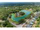 Aerial view shows community building adjacent to a pond and surrounding houses at 7682 St Andrews Blvd, Weeki Wachee, FL 34613