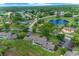 An aerial view shows the community homes surrounded by lush trees and a beautiful pond at 7682 St Andrews Blvd, Weeki Wachee, FL 34613