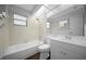 Bathroom with white fixtures, tub with shower and wood-look flooring at 7682 St Andrews Blvd, Weeki Wachee, FL 34613